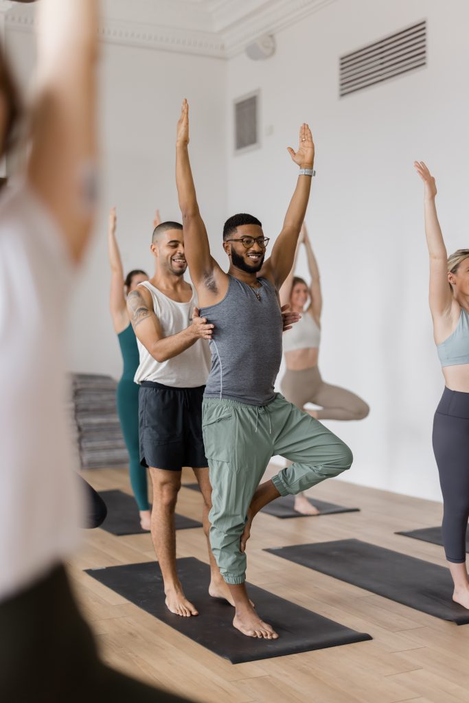 Jessie giving a hands-on adjustment to 200 hour yoga teacher training student Jordan Matthews